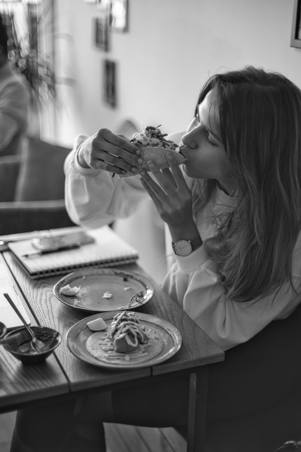 Foto en escala de grises de mujer comiendo