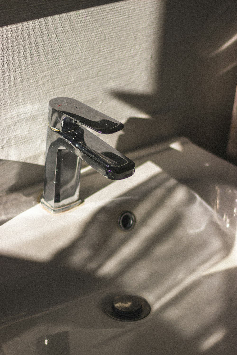 stainless steel faucet on white ceramic sink