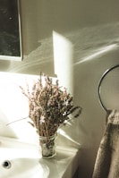 Softly lit scene of dried lavender and rosemary bundles tied with natural twine beside a glass dropper bottle.