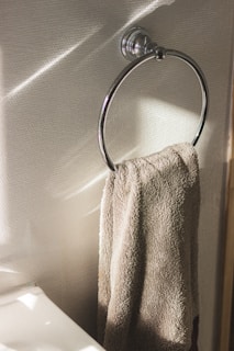 Sleek matte black towel hanger mounted on a white bathroom wall with soft natural light.