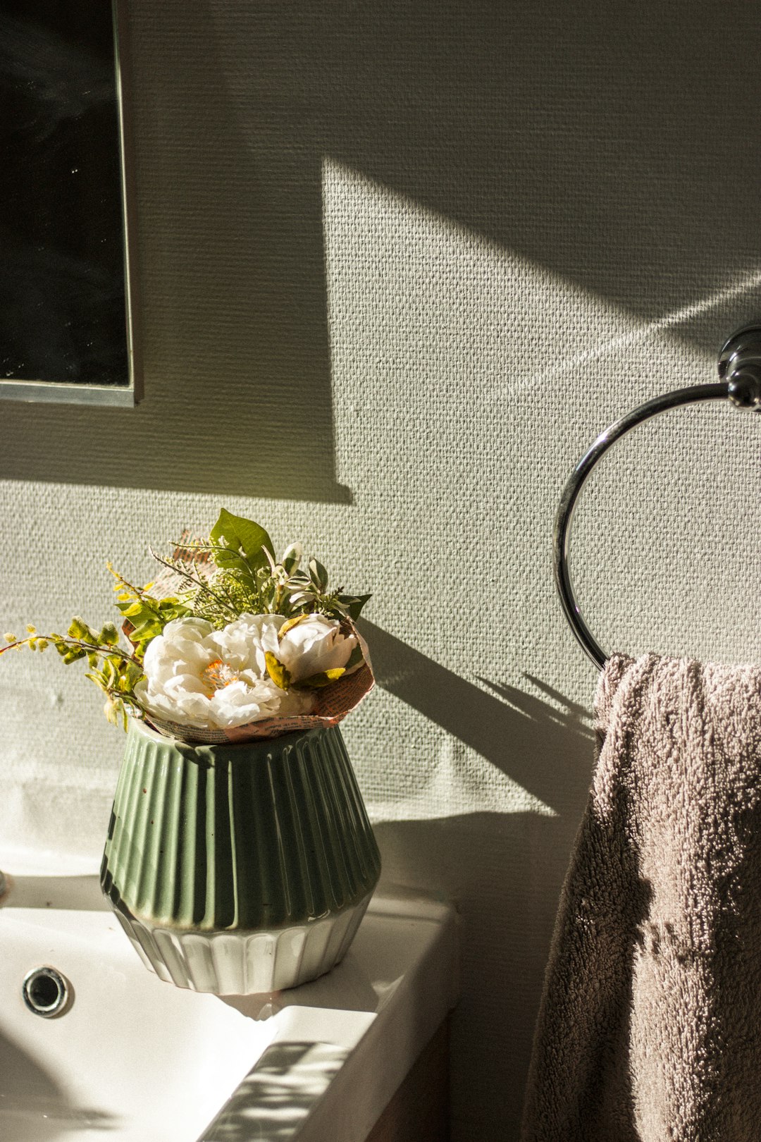 white and green flower on white ceramic vase