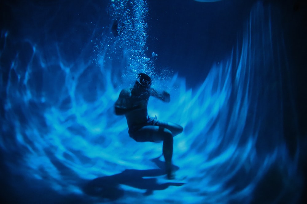 man in black wet suit in water