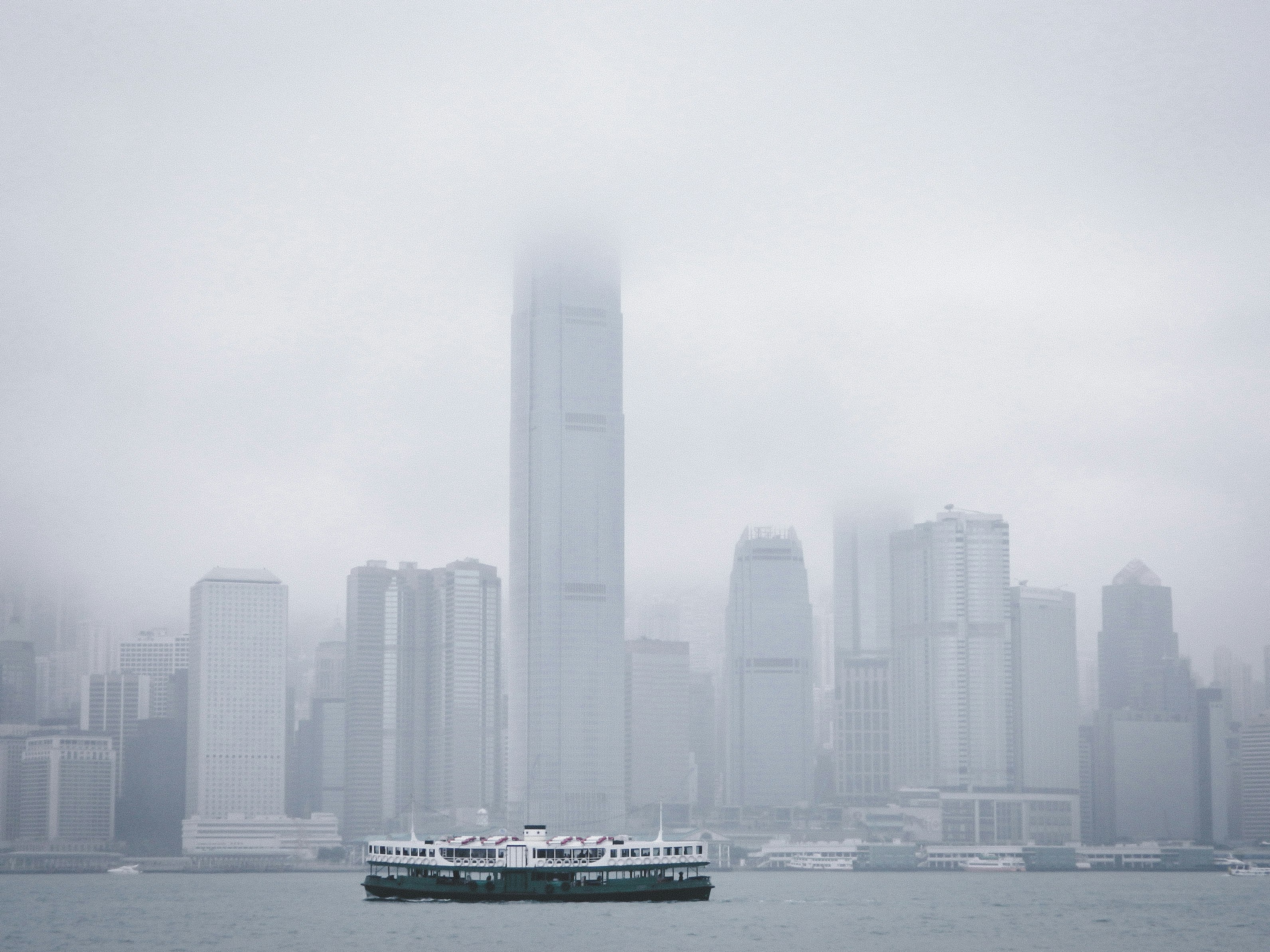 white and black boat on sea near city buildings during daytime