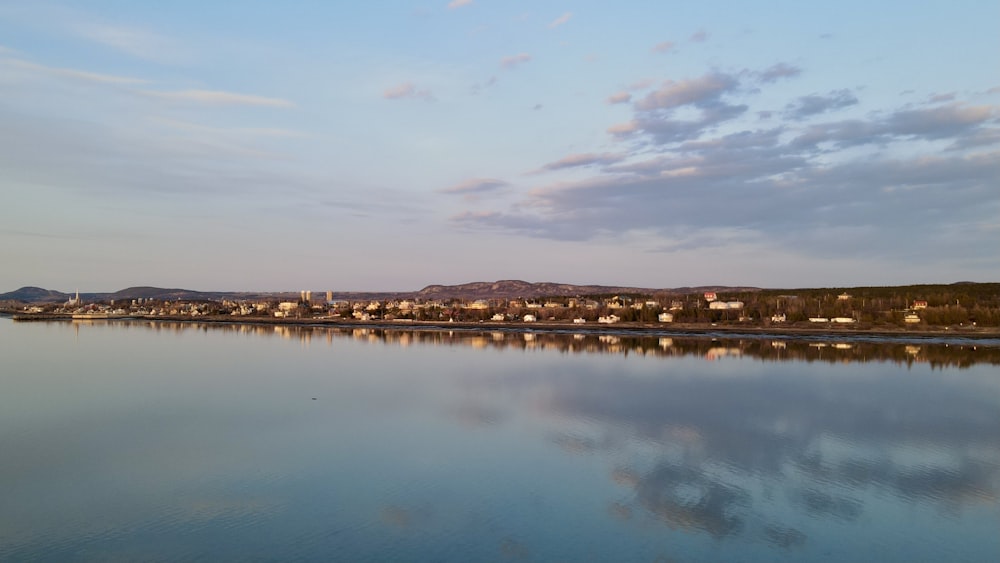 body of water near city buildings under blue sky during daytime