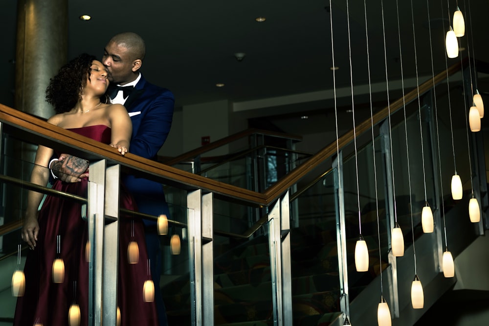 man in blue suit jacket standing beside glass wall