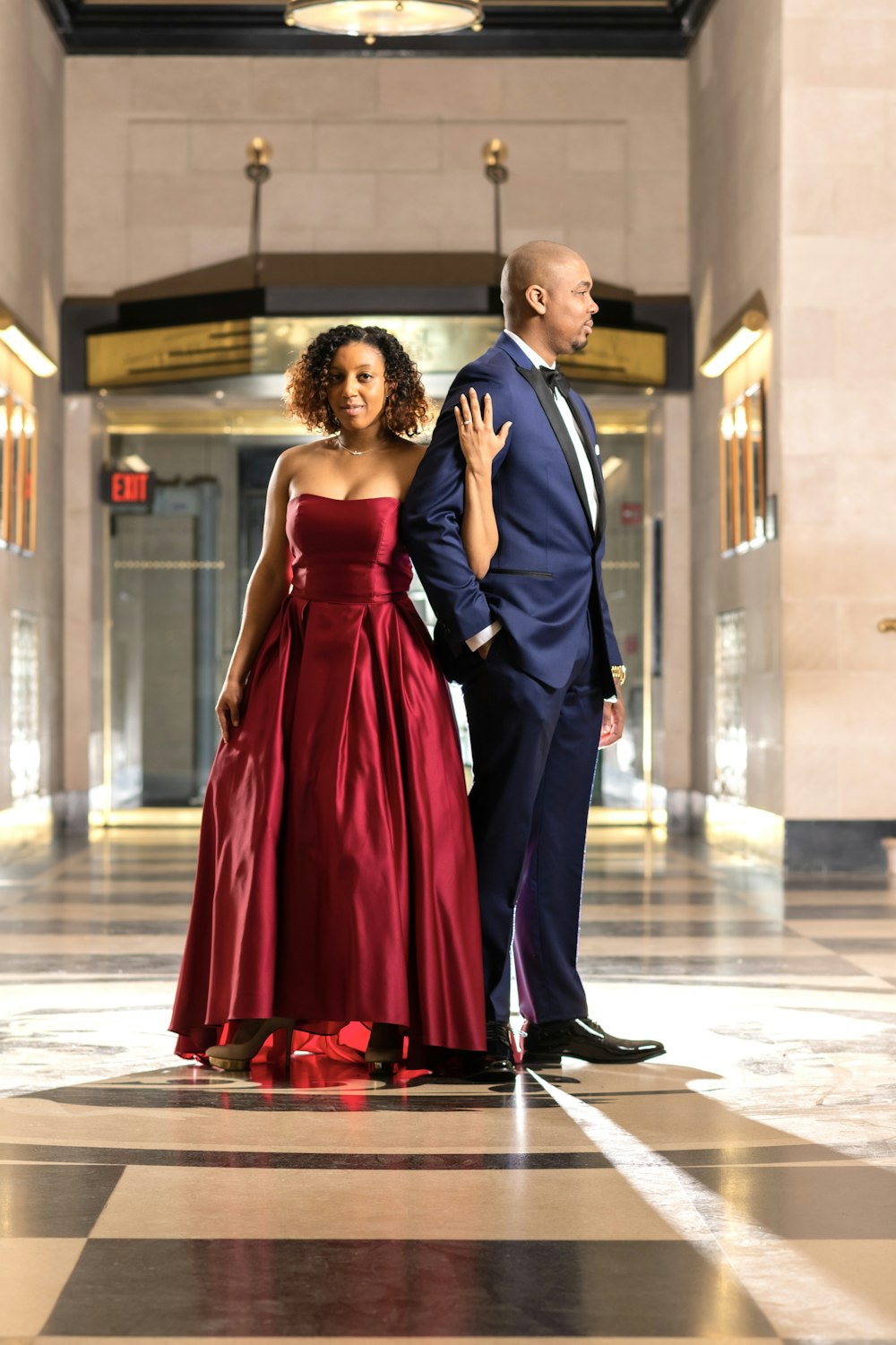 man in black suit jacket and woman in red dress