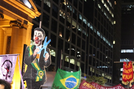 A satirical cartoon of a monstrous corporate CEO being chased by angry protesters wielding stakes.