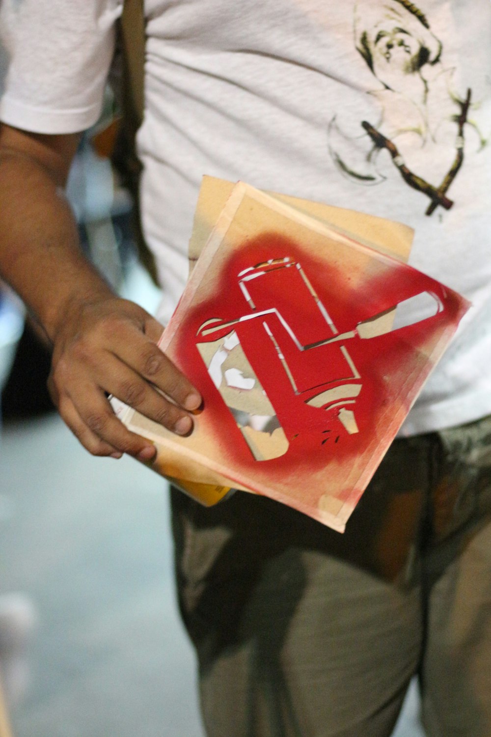 Persona che tiene in mano un pacchetto di plastica bianco e rosso