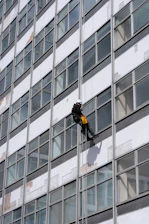 man in black jacket and black pants standing in front of glass window building during daytime