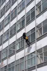 man in black jacket and black pants standing in front of glass window building during daytime