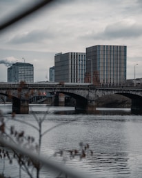bridge over water near city buildings during daytime