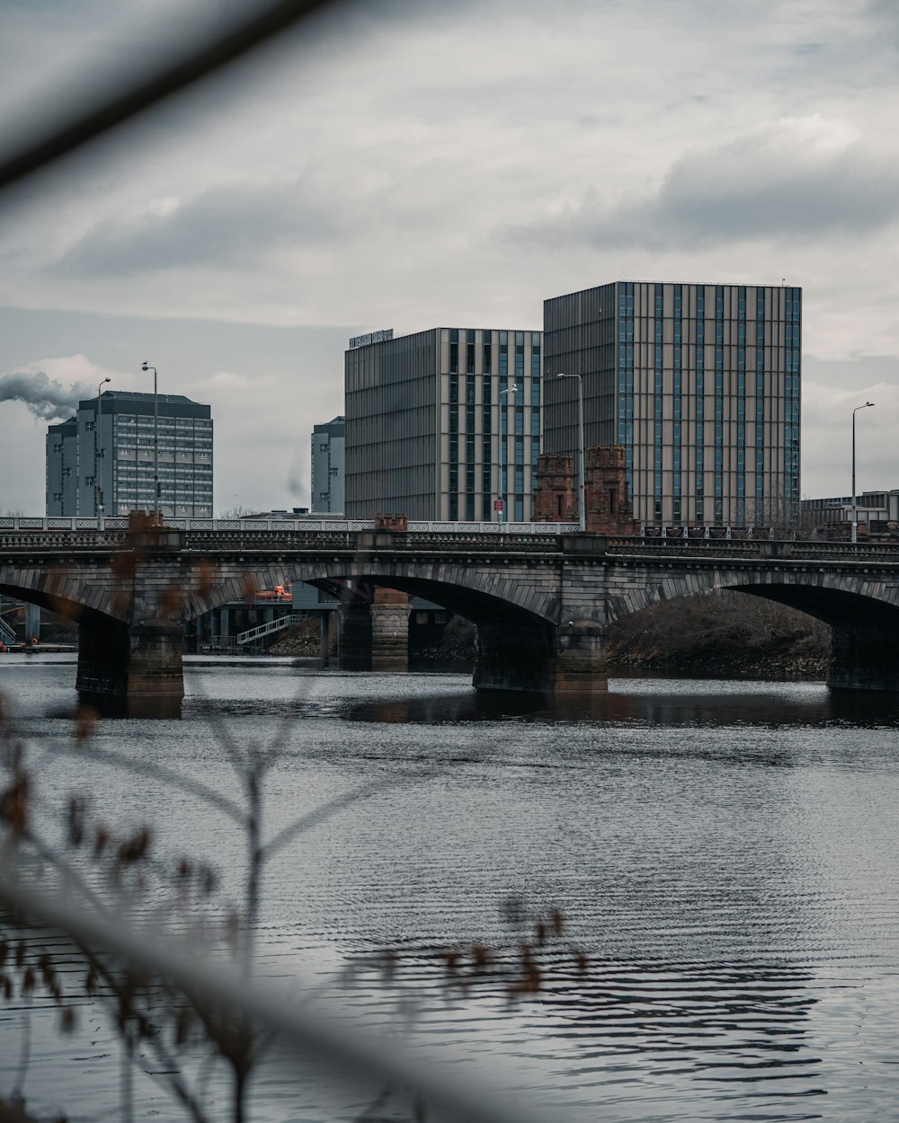 bridge over water near city buildings during daytime