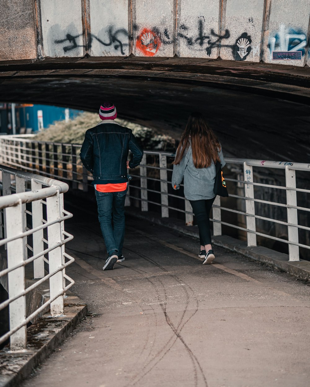 man and woman standing on bridge during daytime