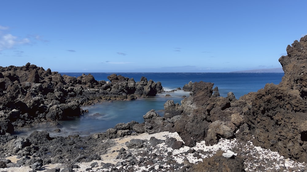 rocky shore under blue sky during daytime