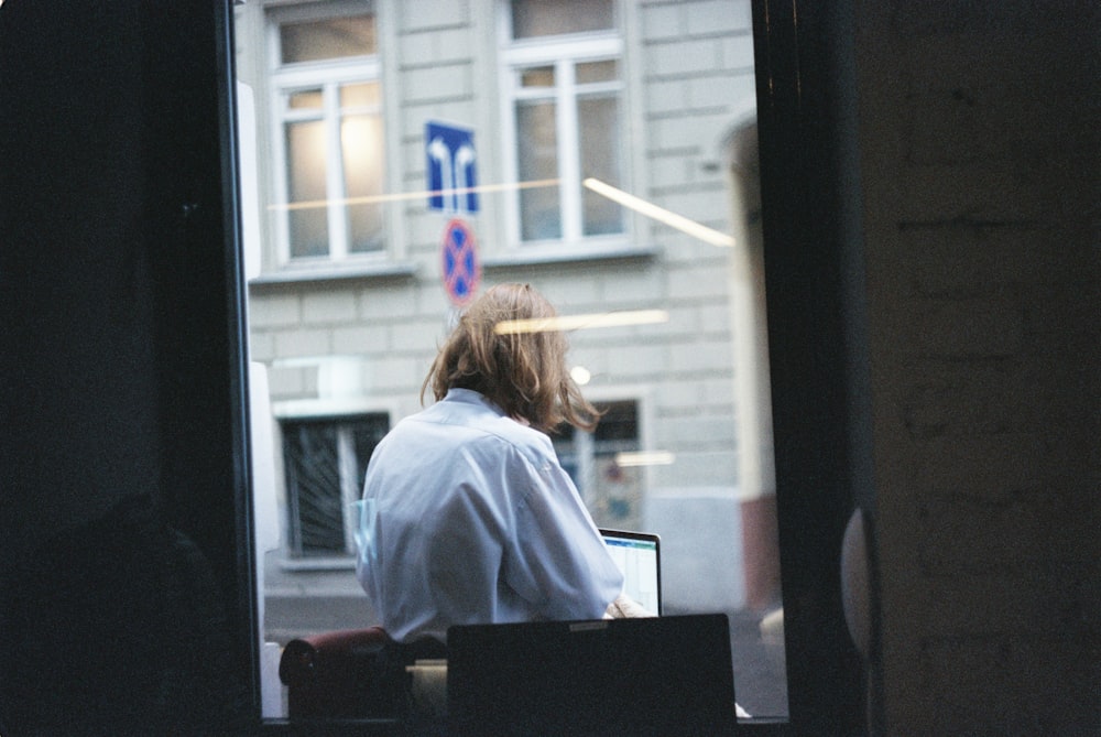 woman in white dress shirt sitting on chair