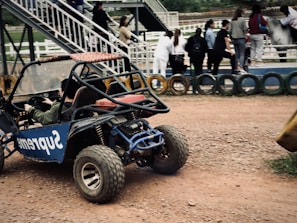 Two buggies racing side by side on sandy trails surrounded by palm trees.
