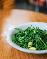 A colorful plate of sautéed greens with garlic and chili flakes.