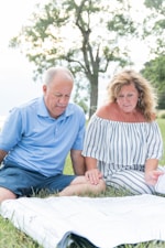 man in blue polo shirt sitting beside woman in white and black stripe dress
