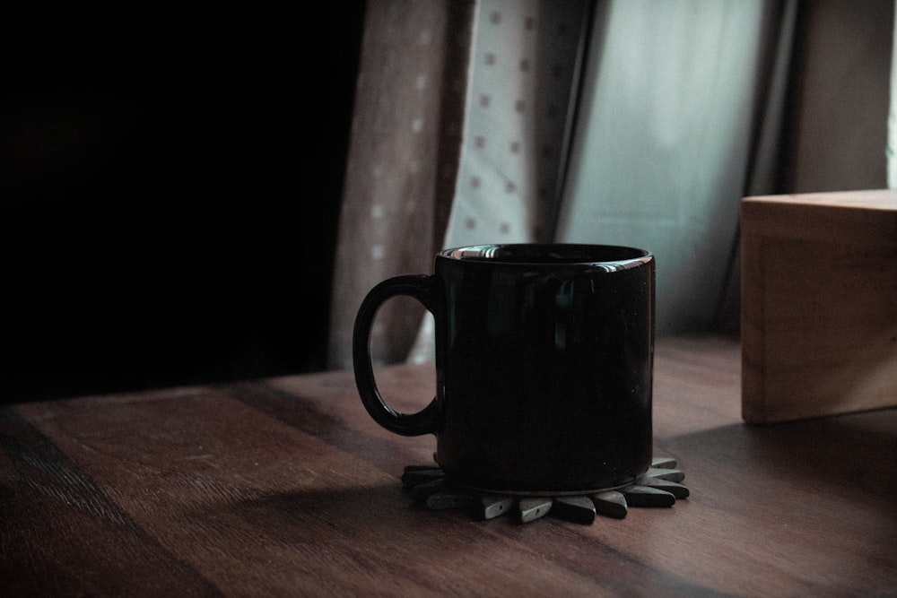 black ceramic mug on brown wooden table