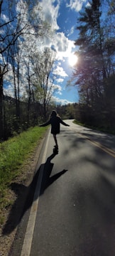 Longboard cruising smoothly down a sunlit urban street.