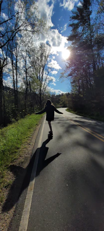Skateboarder cruising a sunlit Baja California street with ocean waves in the background.