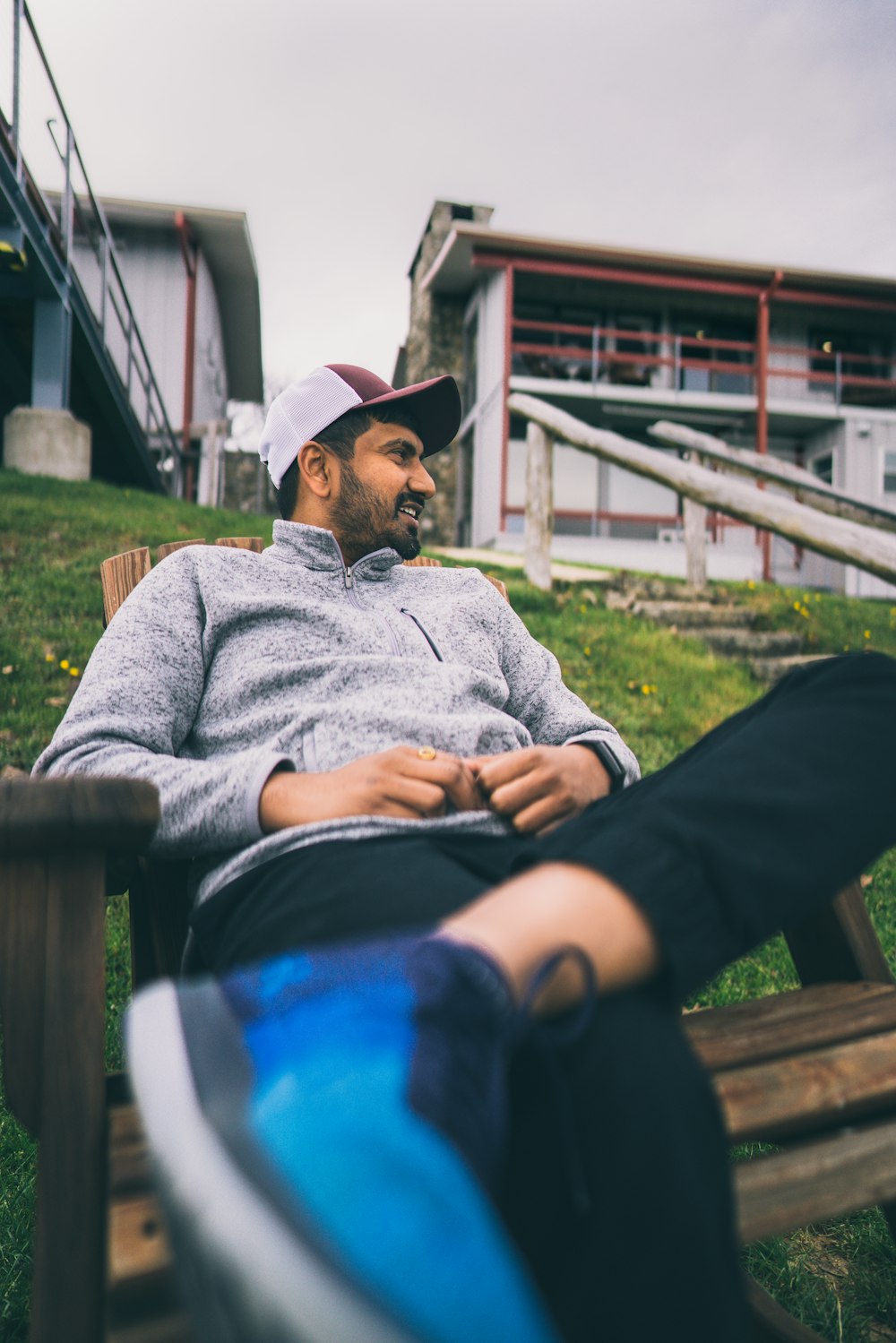 man in gray sweater and black pants sitting on brown wooden bench during daytime