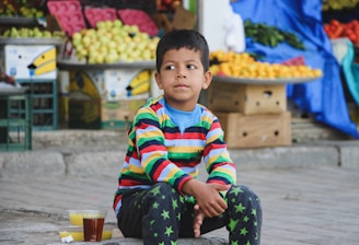 boy in red white and blue striped long sleeve shirt sitting on floor