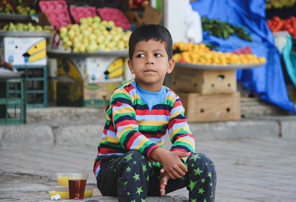 boy in red white and blue striped long sleeve shirt sitting on floor