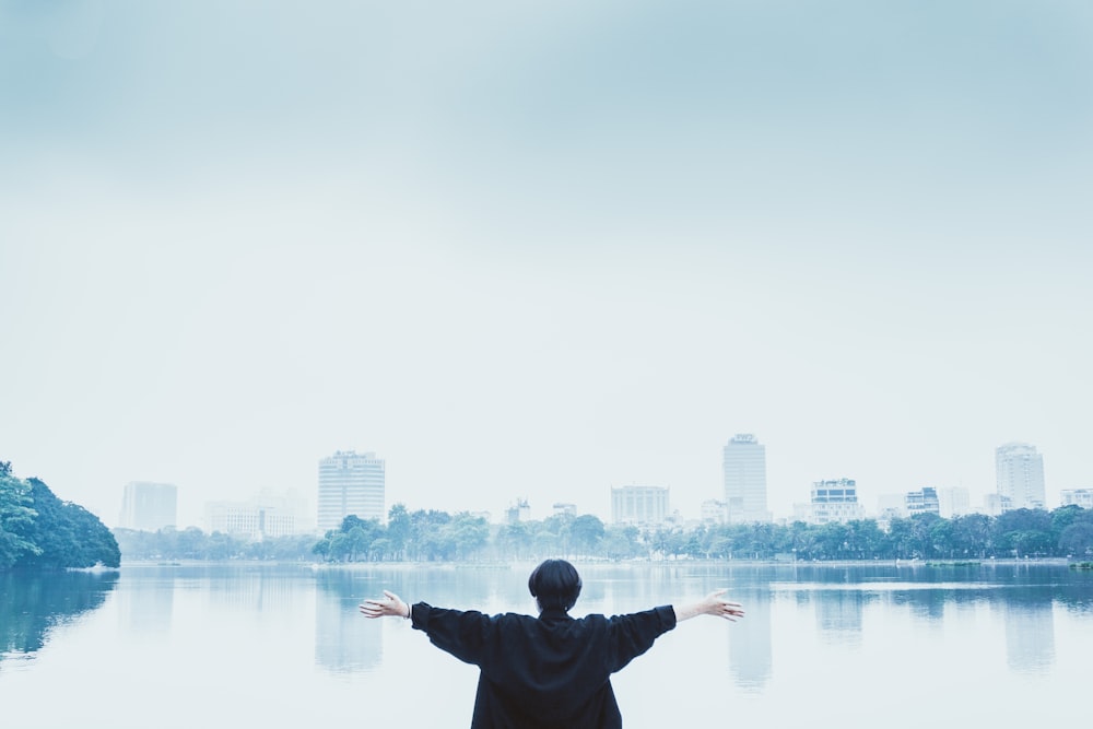 man in black jacket standing near body of water during daytime