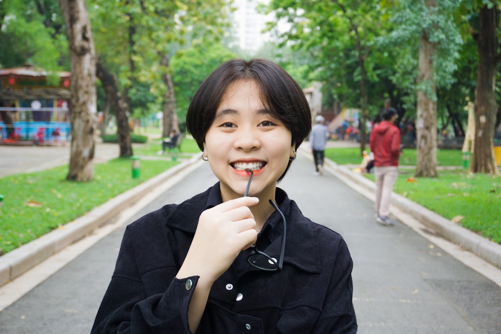 woman in black coat holding cigarette stick