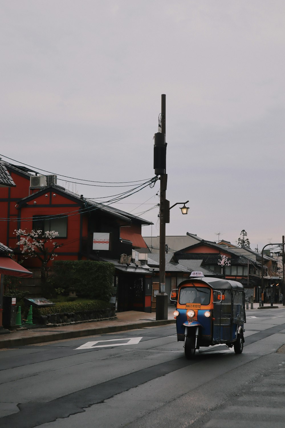 black and yellow auto rickshaw on road near houses during daytime