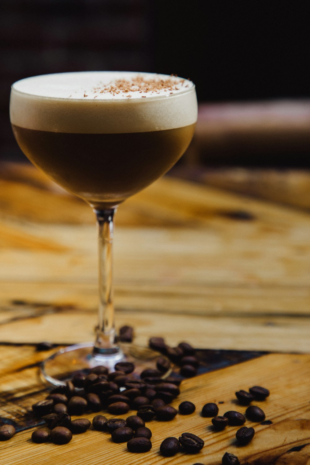 a glass filled with a drink sitting on top of a wooden table