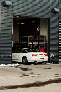 white sedan parked beside gray building
