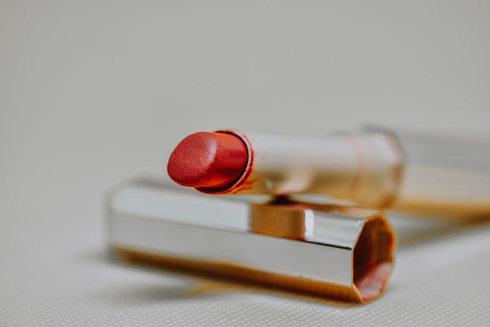 red lipstick on brown wooden table