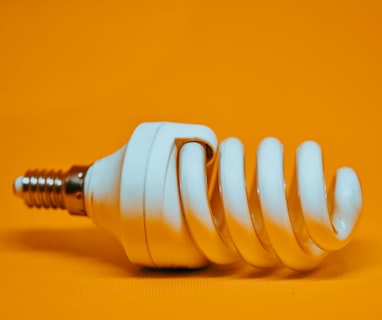 white spiral light bulb on yellow surface