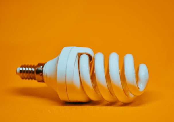 white spiral light bulb on yellow surface