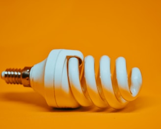 white spiral light bulb on yellow surface