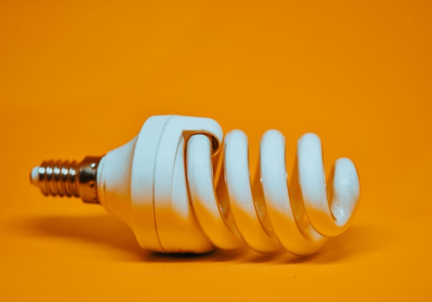 white spiral light bulb on yellow surface