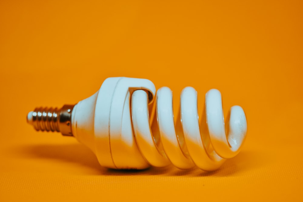 white spiral light bulb on yellow surface