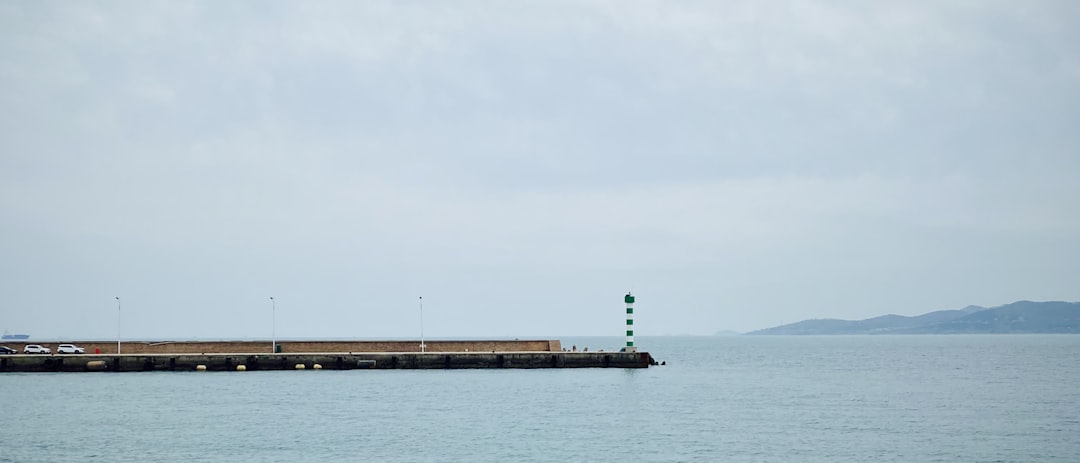 brown wooden dock on sea under white sky during daytime