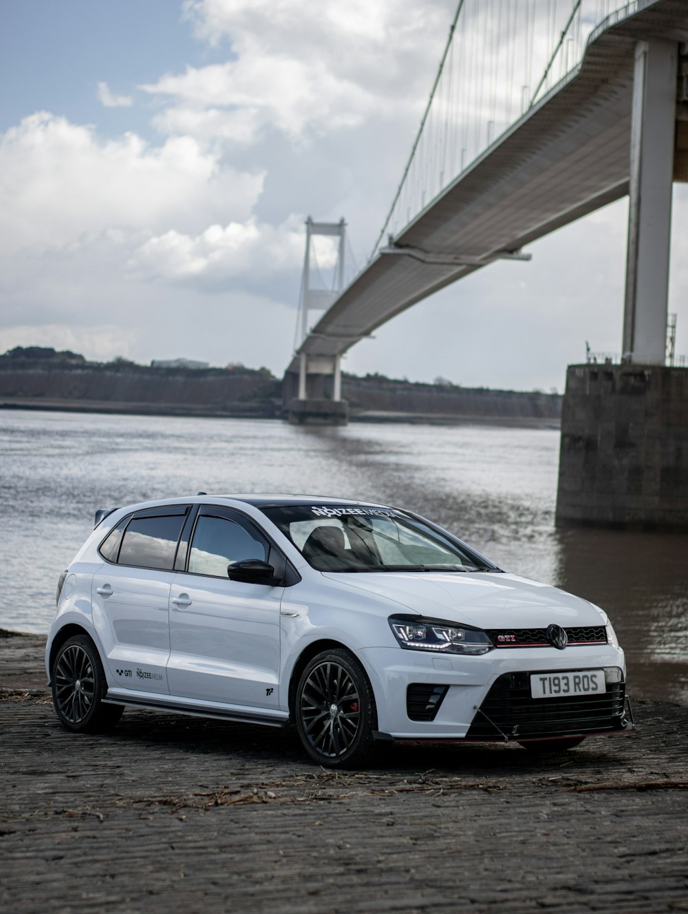 a white car parked in front of a bridge