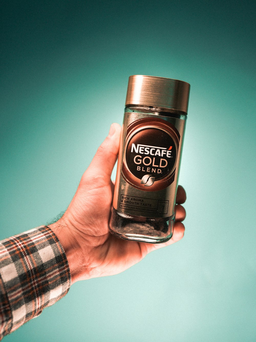 person holding nescafe gold blend bottle