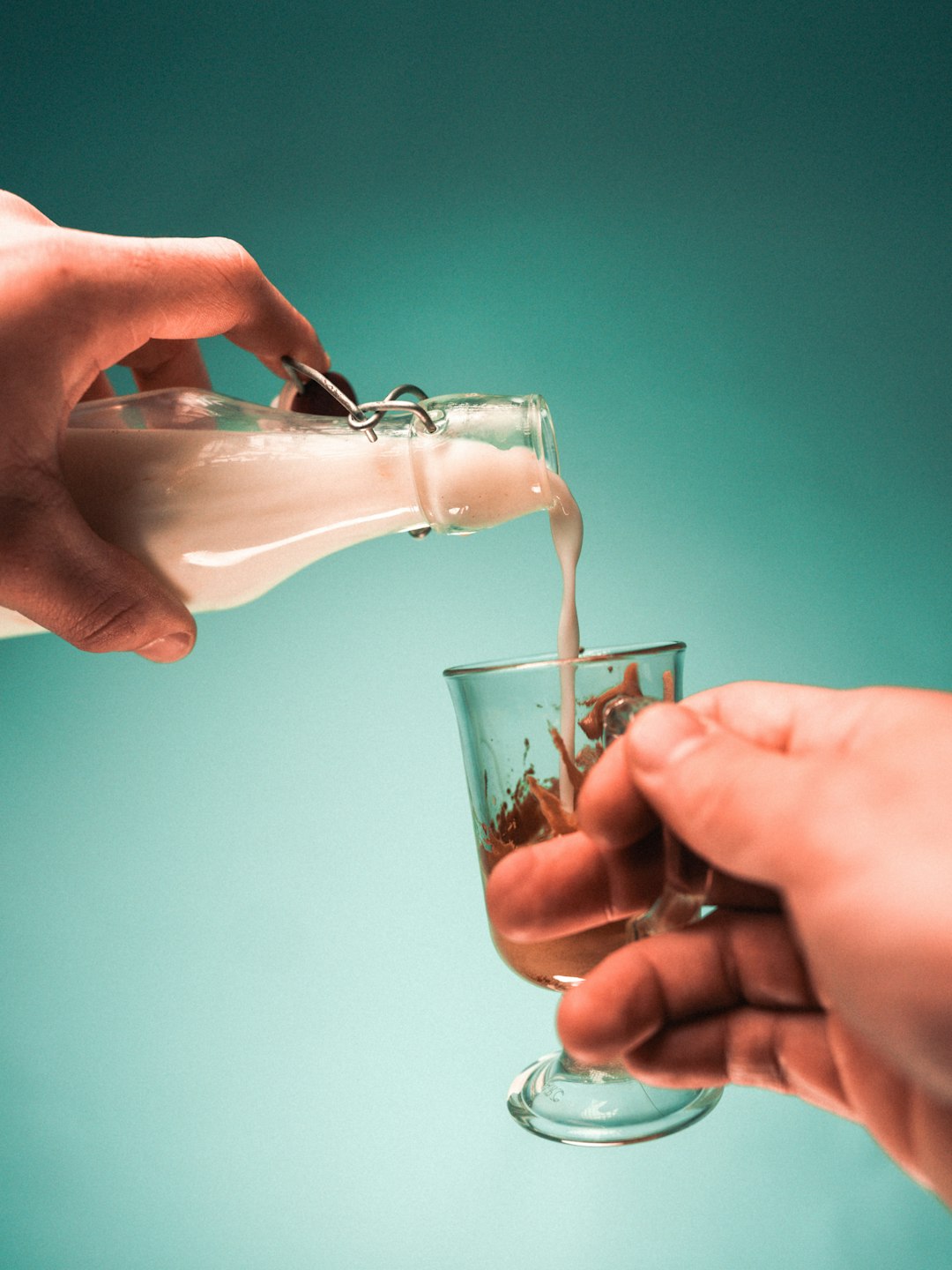 person pouring water on clear drinking glass