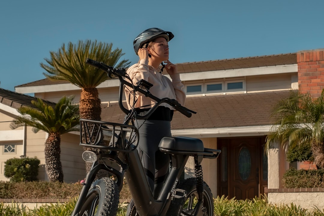 woman in black jacket riding on black bicycle