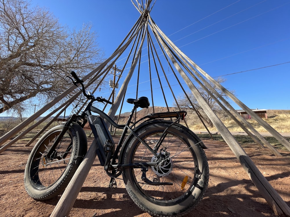 black mountain bike on brown wooden fence