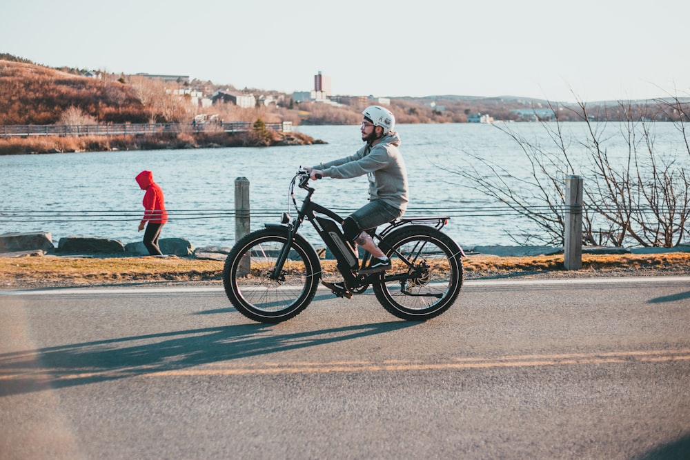 man in red jacket riding on black motorcycle on road during daytime