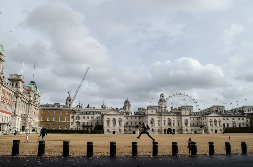 people walking near beige concrete building under white clouds during daytime