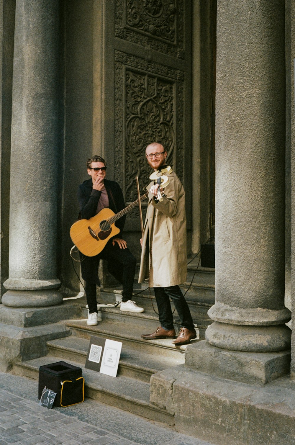 man in brown coat playing guitar