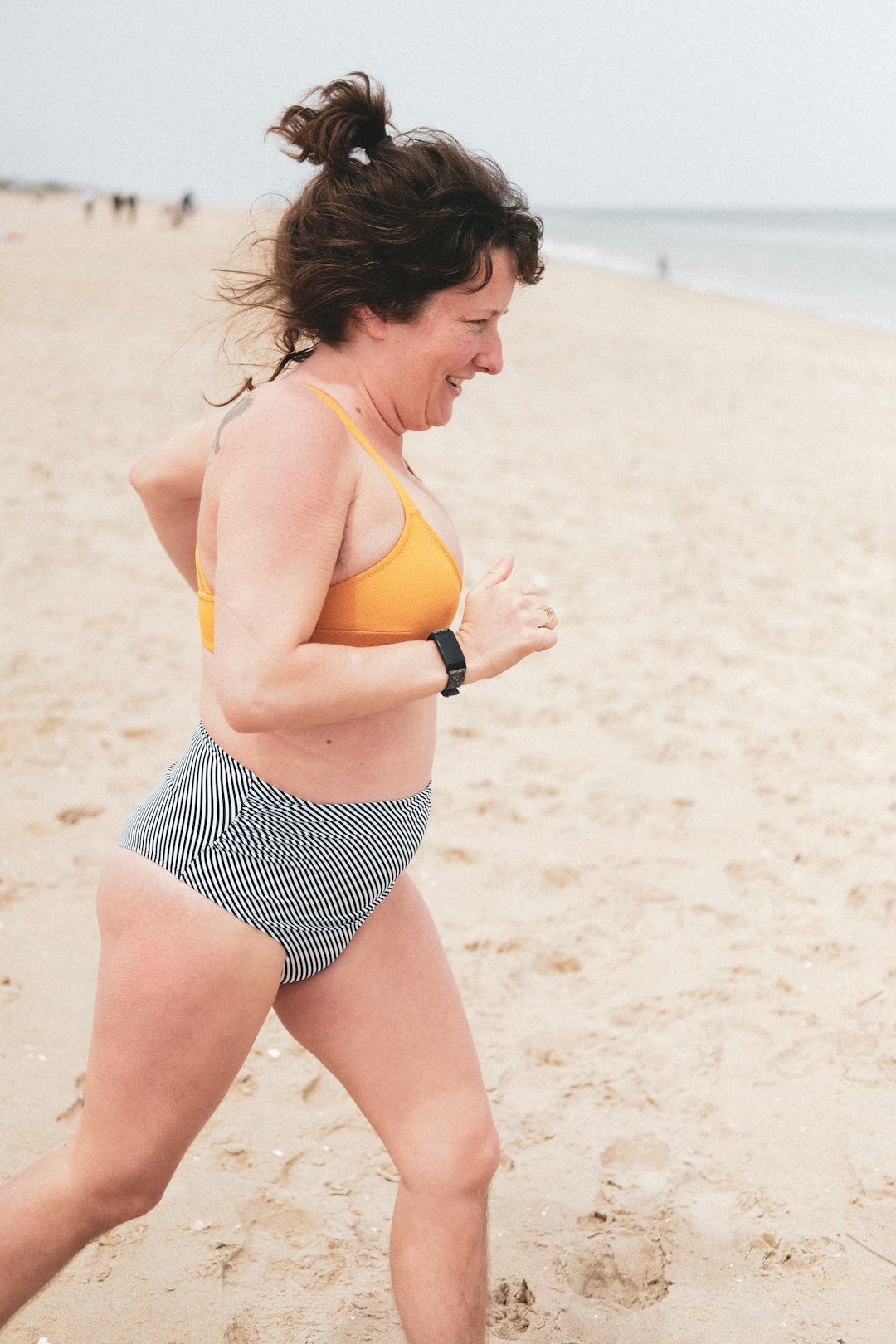 woman in yellow sports bra and black and white polka dot shorts on beach during daytime