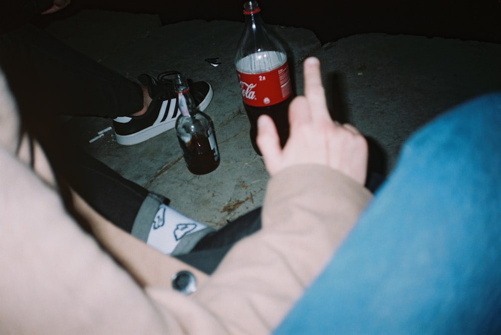 coca cola bottle on black and white flip flops